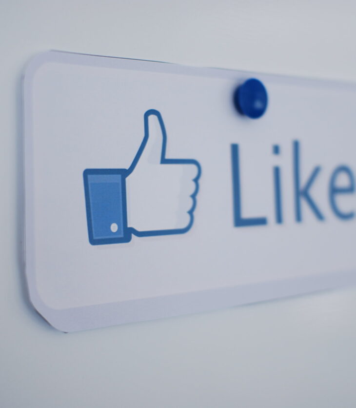 A notice pinned to a white wall with a thumbs up logo