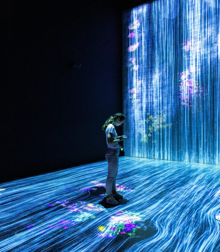 Woman in a dark room looking at her phone